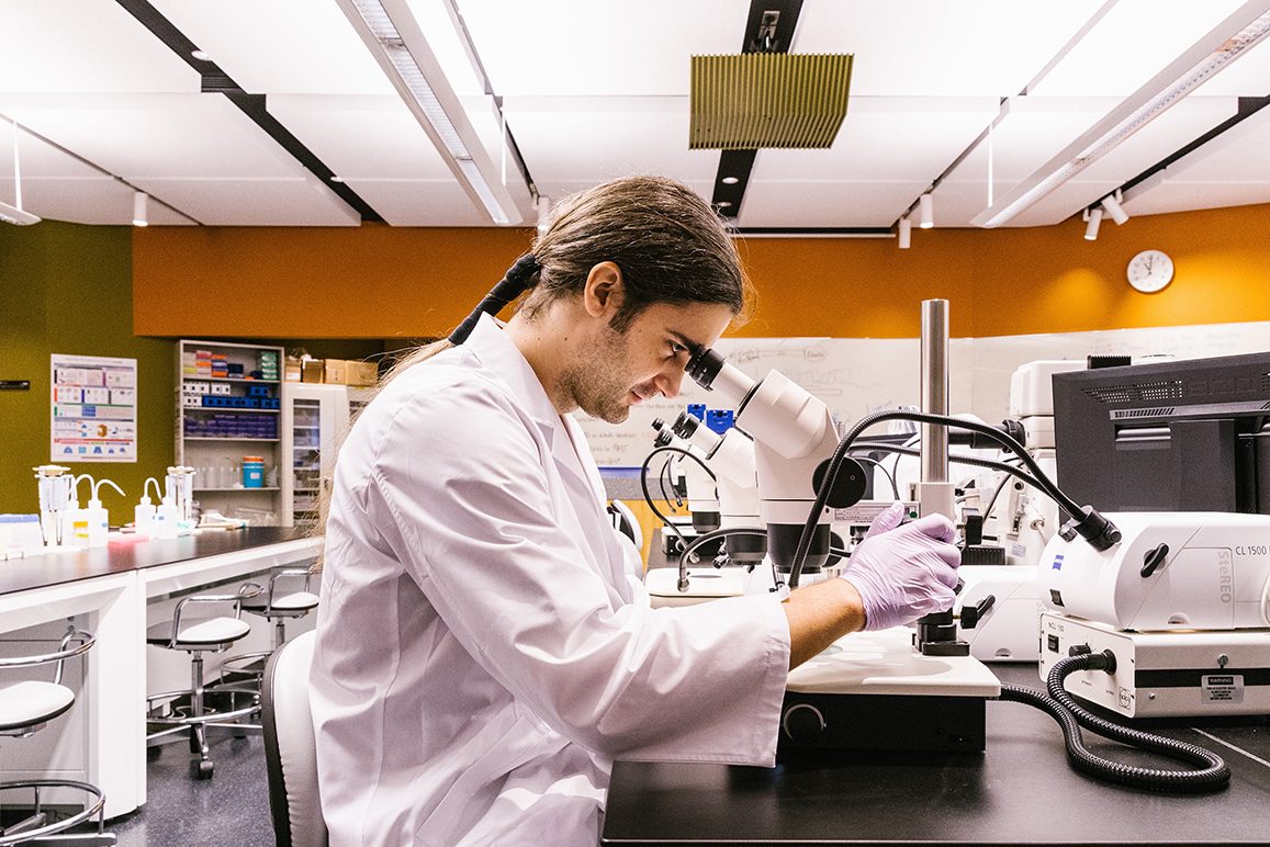 man looking into microscope