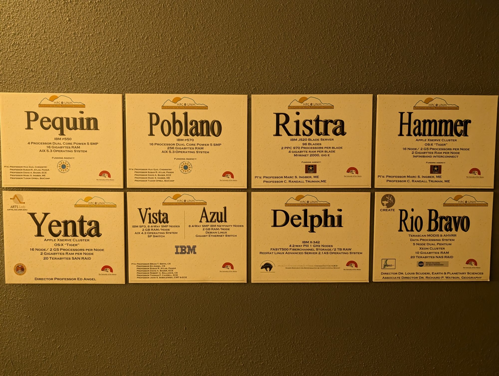 Eight HPC@UNM plaques on the machine-room wall: Pequin, Poblano, Ristra, Hammer, Yenta, Vista and Azul, Delphi, and Rio Bravo